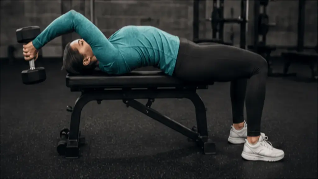 woman performing a dumbbell pullover on a bench with the weight controlled above and behind her head